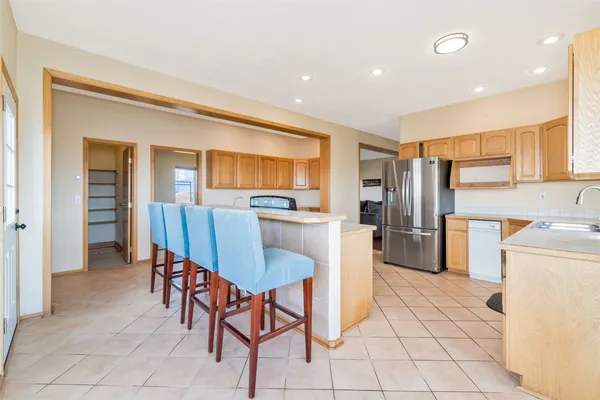 a kitchen with a dining table chairs and refrigerator