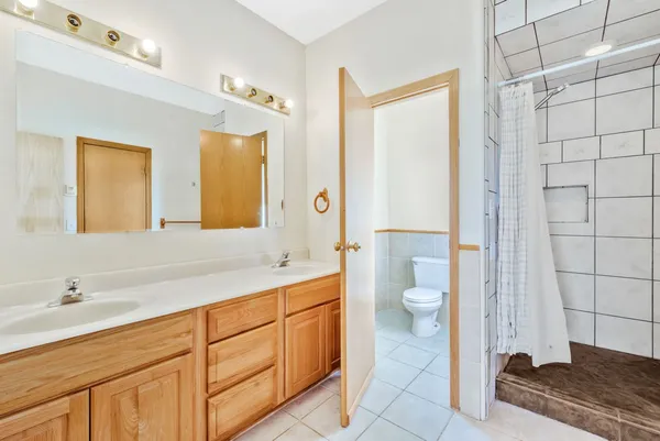 a spacious bathroom with a granite countertop sink toilet and shower