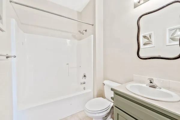 a bathroom with a white toilet sitting next to a white sink and a shower curtain