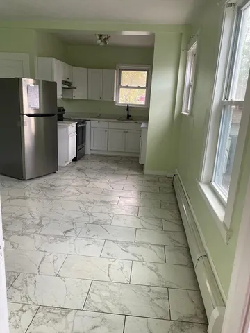 a kitchen with granite countertop a refrigerator a sink a stove a microwave and cabinets