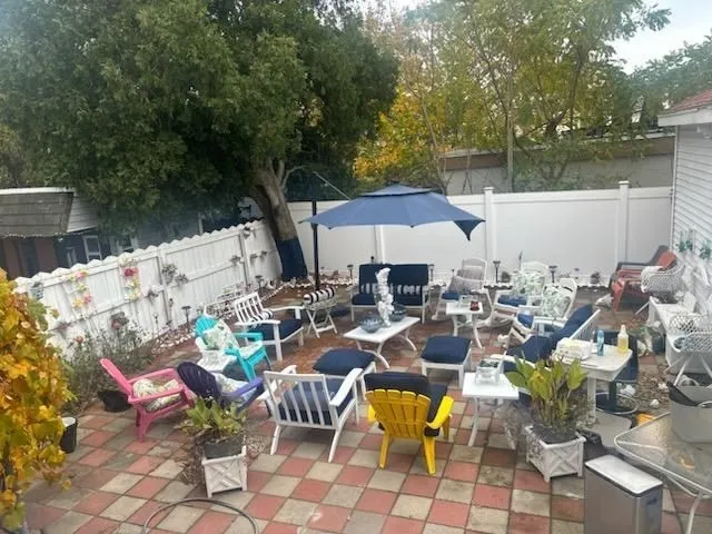a view of a patio with table and chairs potted plants with wooden fence