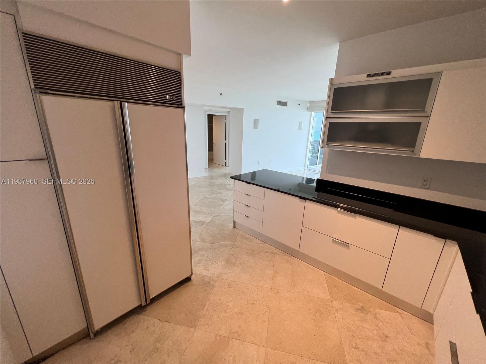 400 Alton Road, Unit LPH3007 Miami Beach, FL 33139 - Photo 14 of 51 a kitchen with a refrigerator and cabinets