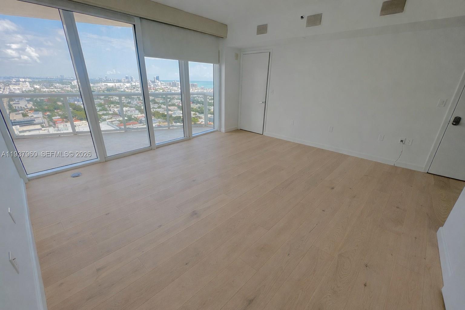 400 Alton Road, Unit LPH3007 Miami Beach, FL 33139 - Photo 19 of 51 an empty room with wooden floor and windows