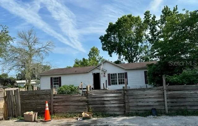 a view of a yard in front of a house with large tree