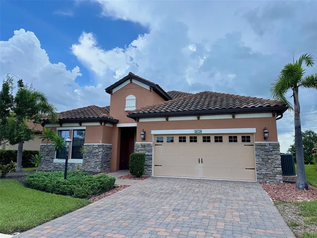 a view of a white house with a yard and large tree