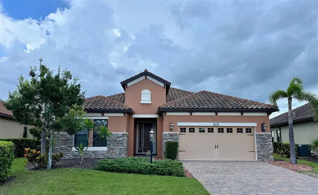 a front view of a house with a garden and plants