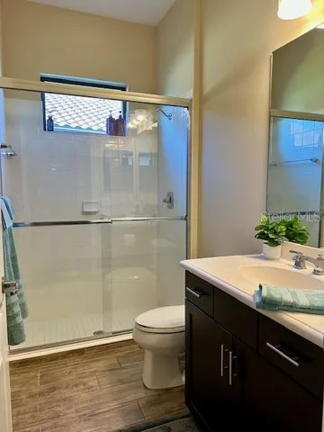 a bathroom with a granite countertop sink toilet and shower