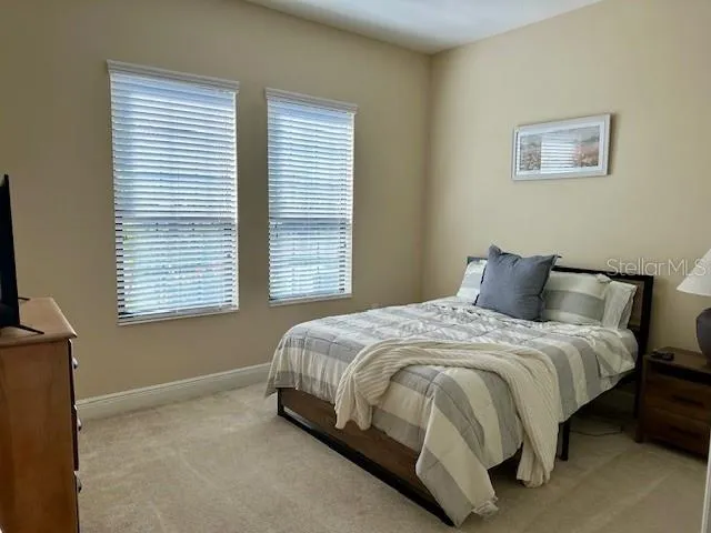 a large bed sitting in a bedroom next to a window
