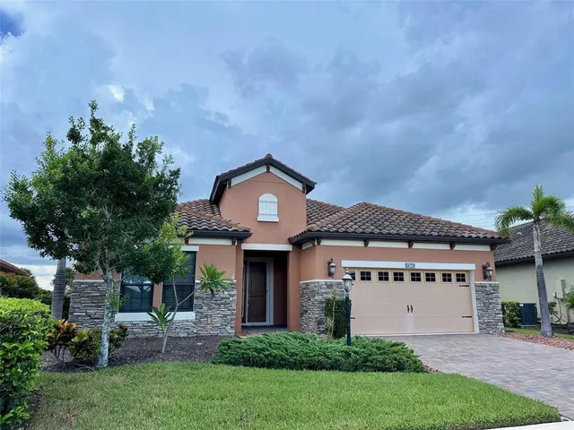 a front view of a house with a garden and plants