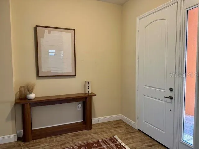 a view of a hallway with wooden floor and a mirror