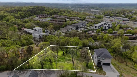 an aerial view of residential houses with outdoor space and trees