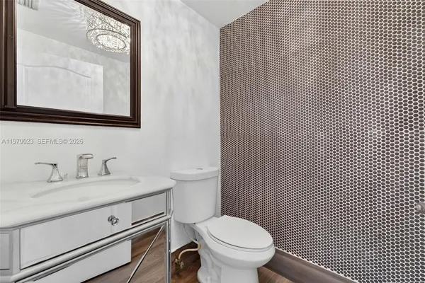 a bathroom with a toilet sink vanity and mirror