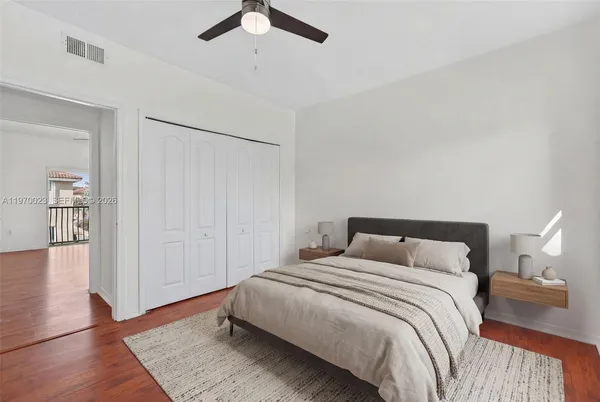 a view of empty room with wooden floor and fan