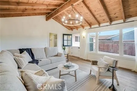 a living room with furniture a wooden floor and a large window