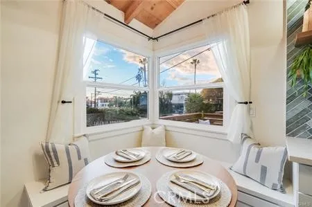 a view of a dining room with furniture large windows and a chandelier