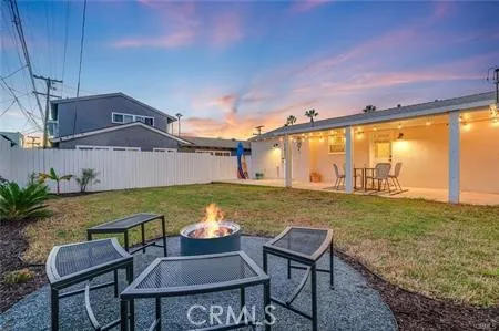 a view of a chairs and table in the patio next to a yard