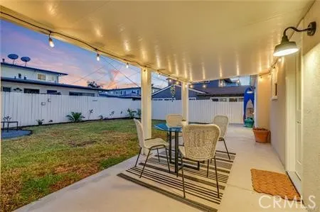 a outdoor space with the couches and dining table under an umbrella