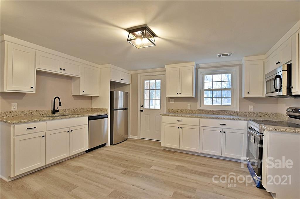 2441 State Rd S-29-305 Lancaster, SC 29720 - Photo 8 of 29 a large white kitchen with granite countertop a sink a window and stainless steel appliances