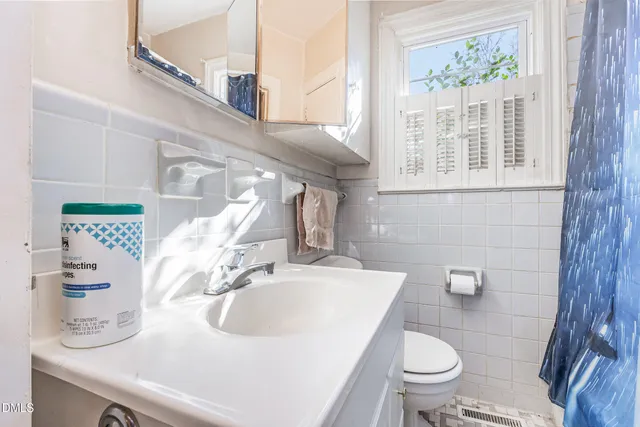 a bathroom with a sink a toilet and a mirror