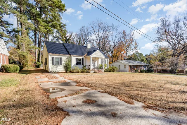 a front view of a house with a yard and trees