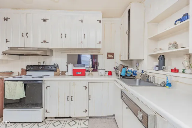 a kitchen with white cabinets and white appliances