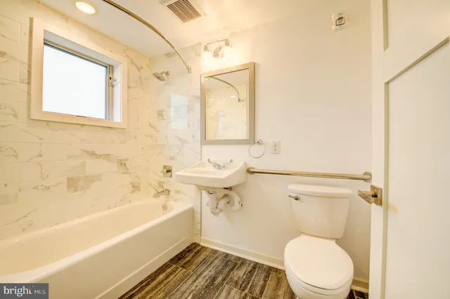 a bathroom with a toilet a sink and bathtub