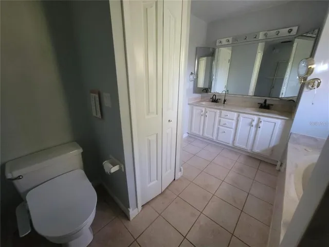 a bathroom with a granite countertop toilet and sink