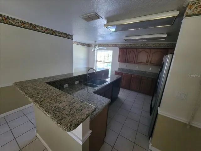 a kitchen with granite countertop a sink a stove and cabinets