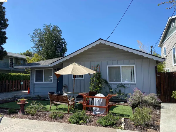 a view of house with yard and outdoor seating