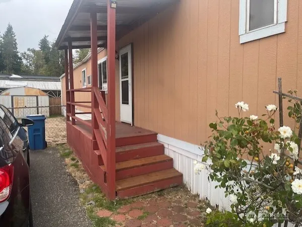a view of a house with a small yard and wooden floor and fence