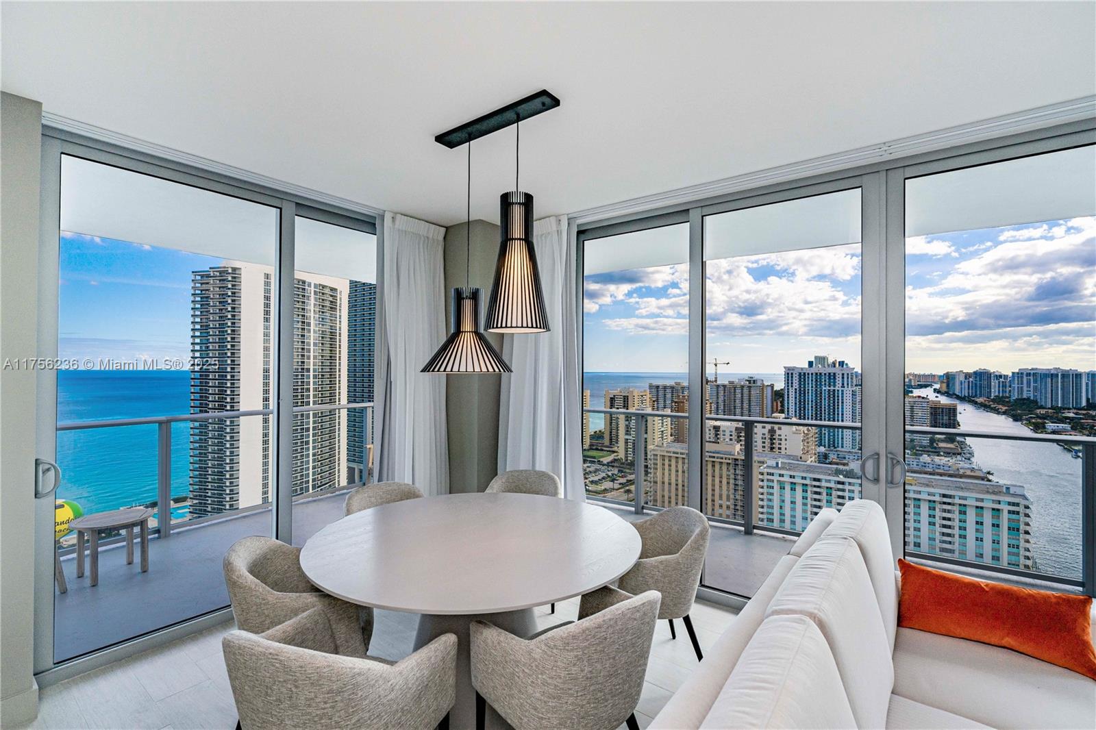 a dining room with furniture and a floor to ceiling window
