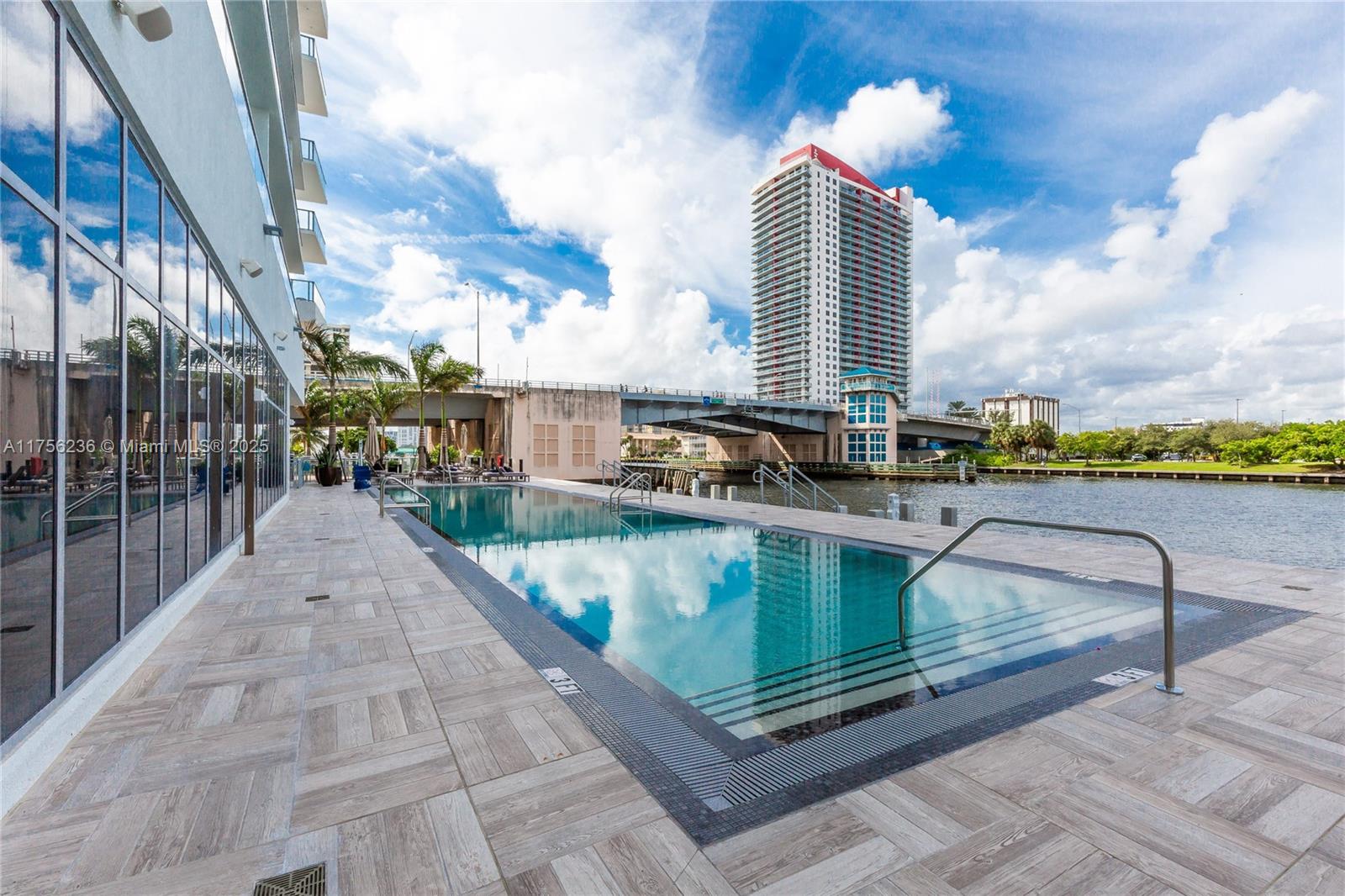 4010 South Ocean Drive, Unit R1609 Hollywood, FL 33019 - Photo 30 of 50 a view of a swimming pool with a lounge chairs