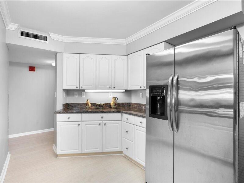1044 Highway 98, Unit 101 Destin, FL 32541 - Photo 11 of 29 a kitchen with stainless steel appliances kitchen island a refrigerator sink and cabinets