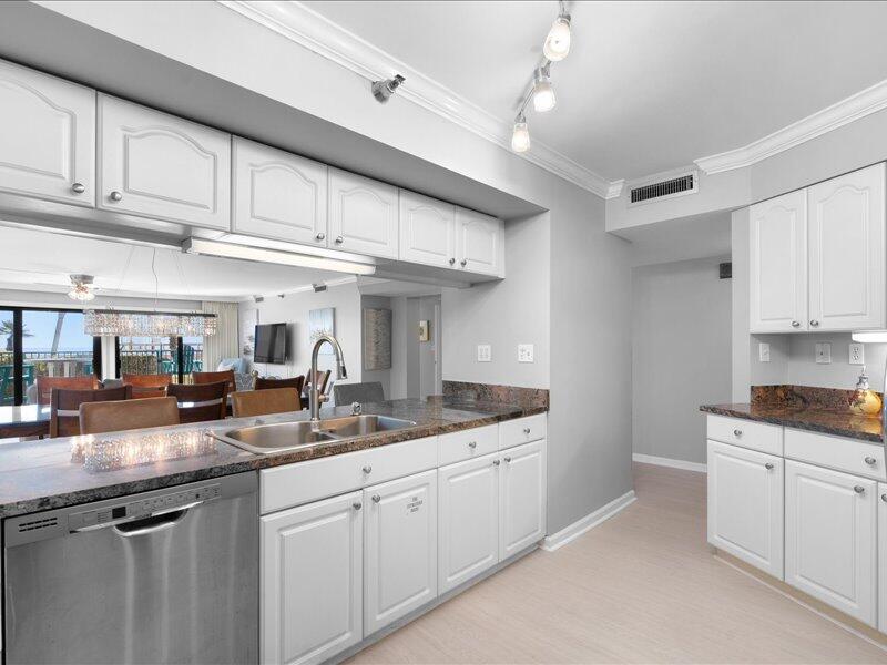 1044 Highway 98, Unit 101 Destin, FL 32541 - Photo 12 of 29 a kitchen with granite countertop a sink and cabinets