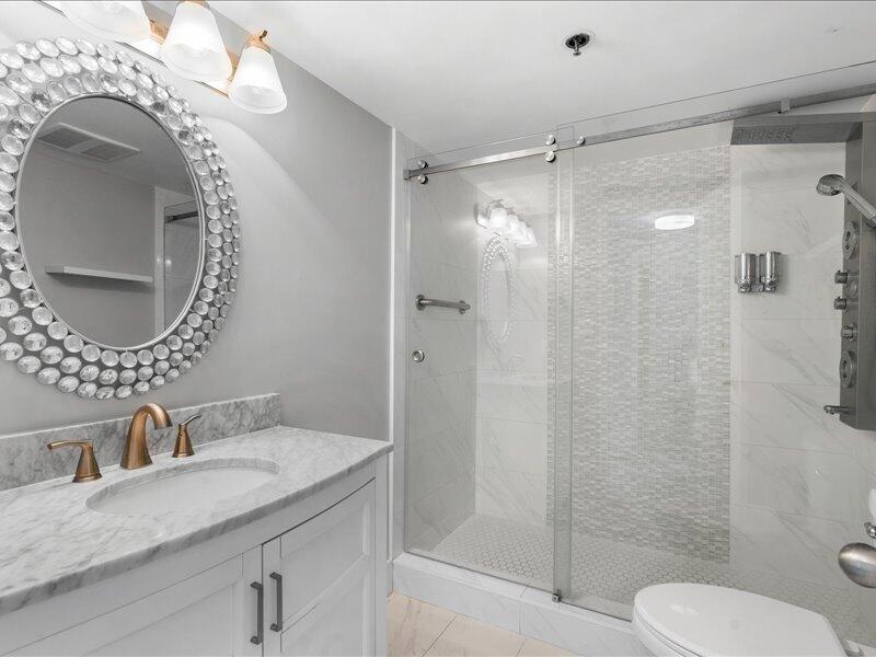 1044 Highway 98, Unit 101 Destin, FL 32541 - Photo 17 of 29 a bathroom with a granite countertop sink mirror vanity and toilet