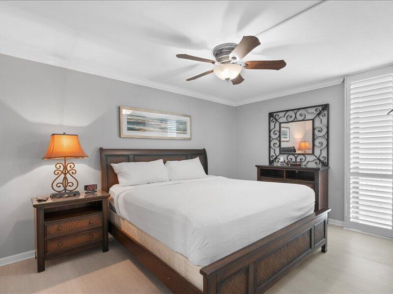 1044 Highway 98, Unit 101 Destin, FL 32541 - Photo 20 of 29 a bedroom with a bed and a chandelier