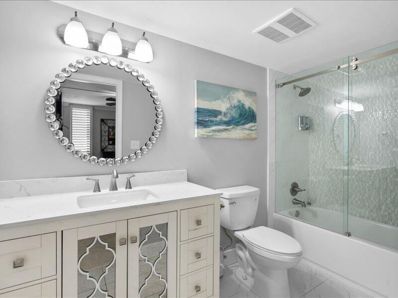 1044 Highway 98, Unit 101 Destin, FL 32541 - Photo 21 of 29 a bathroom with a toilet a sink and mirror