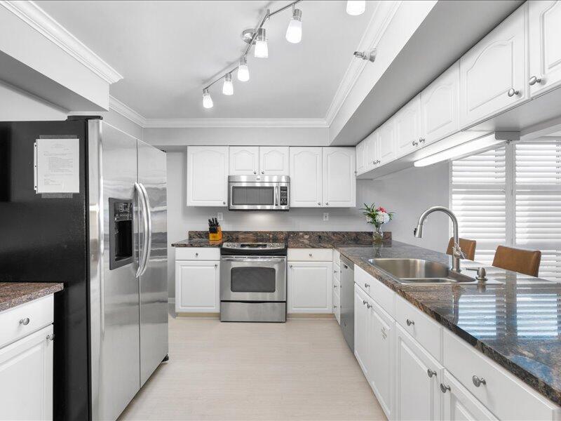 1044 Highway 98, Unit 101 Destin, FL 32541 - Photo 9 of 29 a kitchen with stainless steel appliances granite countertop a sink and refrigerator