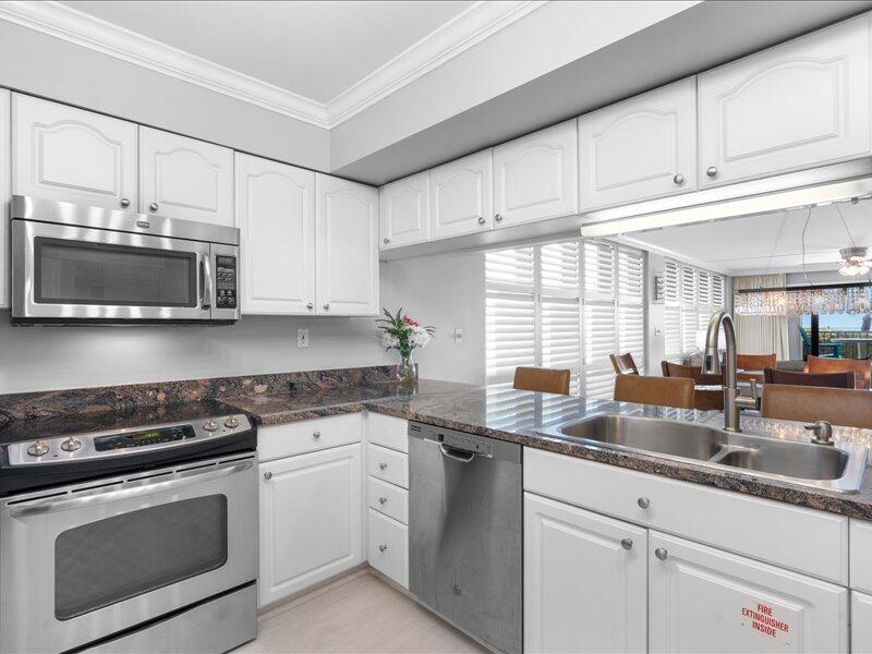 1044 Highway 98, Unit 101 Destin, FL 32541 - Photo 10 of 29 a kitchen with stainless steel appliances granite countertop a sink a stove and a microwave