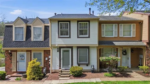 front view of a brick house with a yard