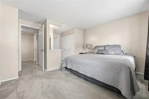 a bedroom with a bed and a refrigerator