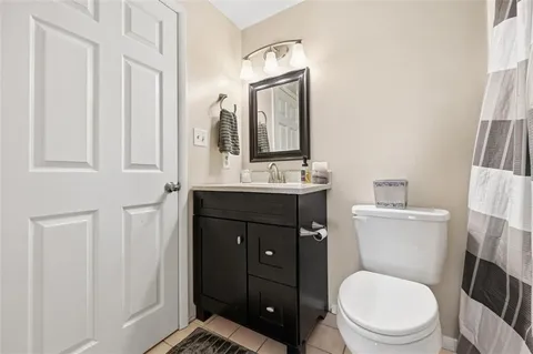 a bathroom with a toilet a sink a vanity and mirror