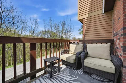 a balcony with wooden floor and outdoor seating