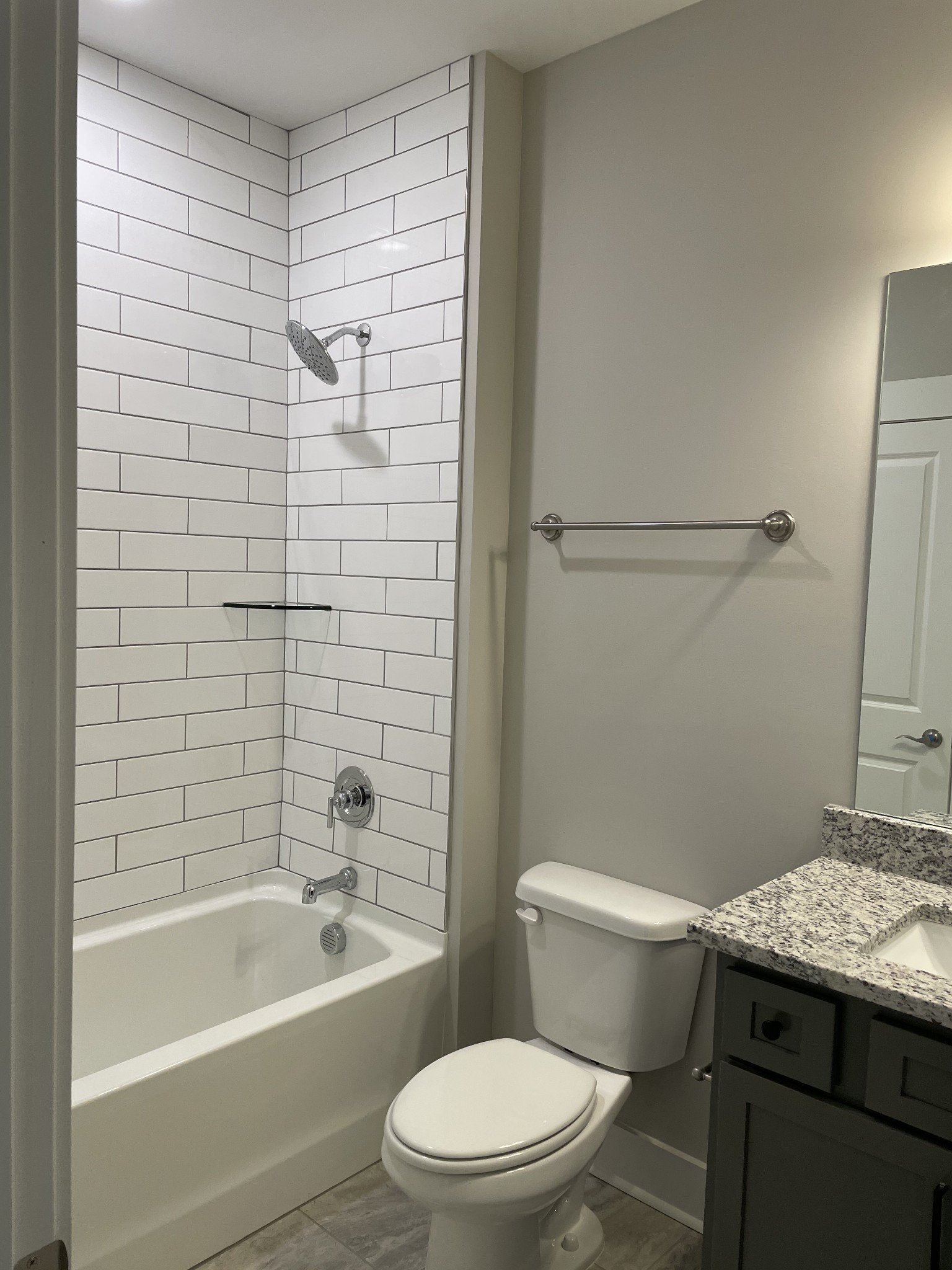 217 Stonecrest Drive, Unit 217 Nashville, TN 37209 - Photo 11 of 20 a bathroom with a granite countertop toilet a sink and bathtub
