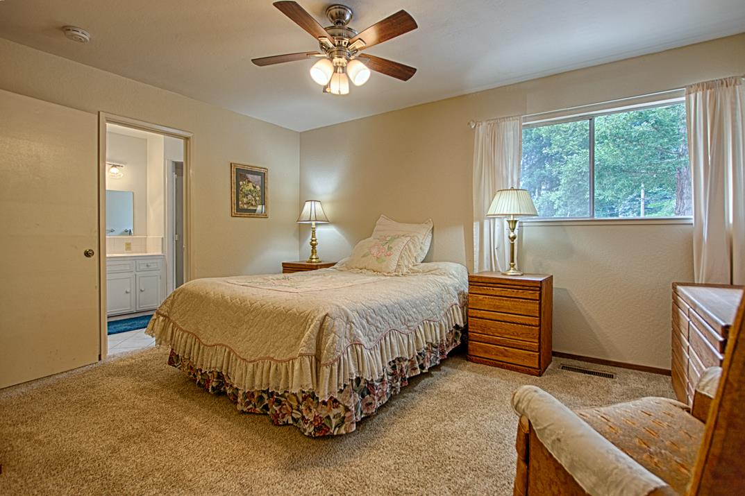 7 Plaza Mount Hermon, CA 95041 - Photo 21 of 26 a spacious bedroom with a bed and a chandelier