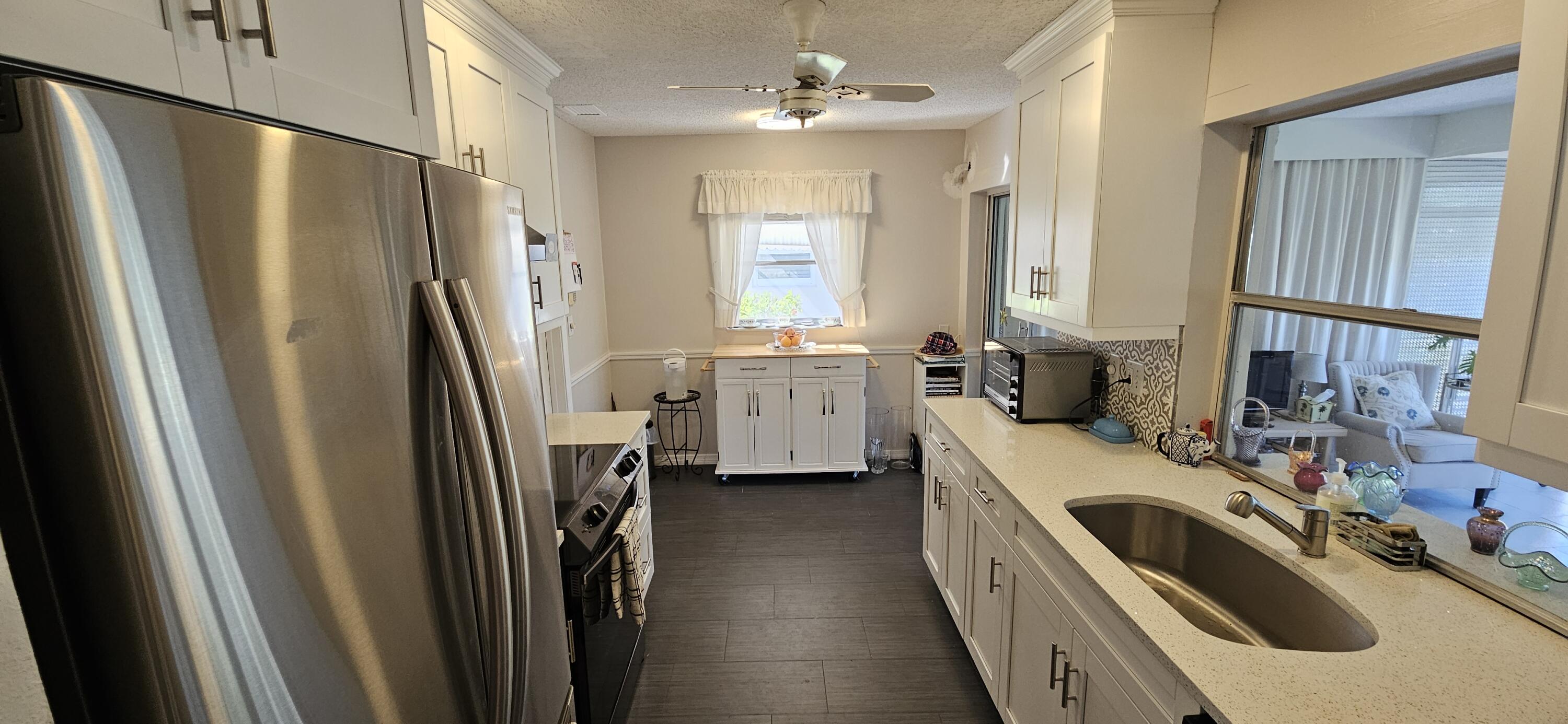 5213 Michael Drive West Palm Beach, FL 33417 - Photo 11 of 47 a kitchen with a sink a refrigerator and a stove