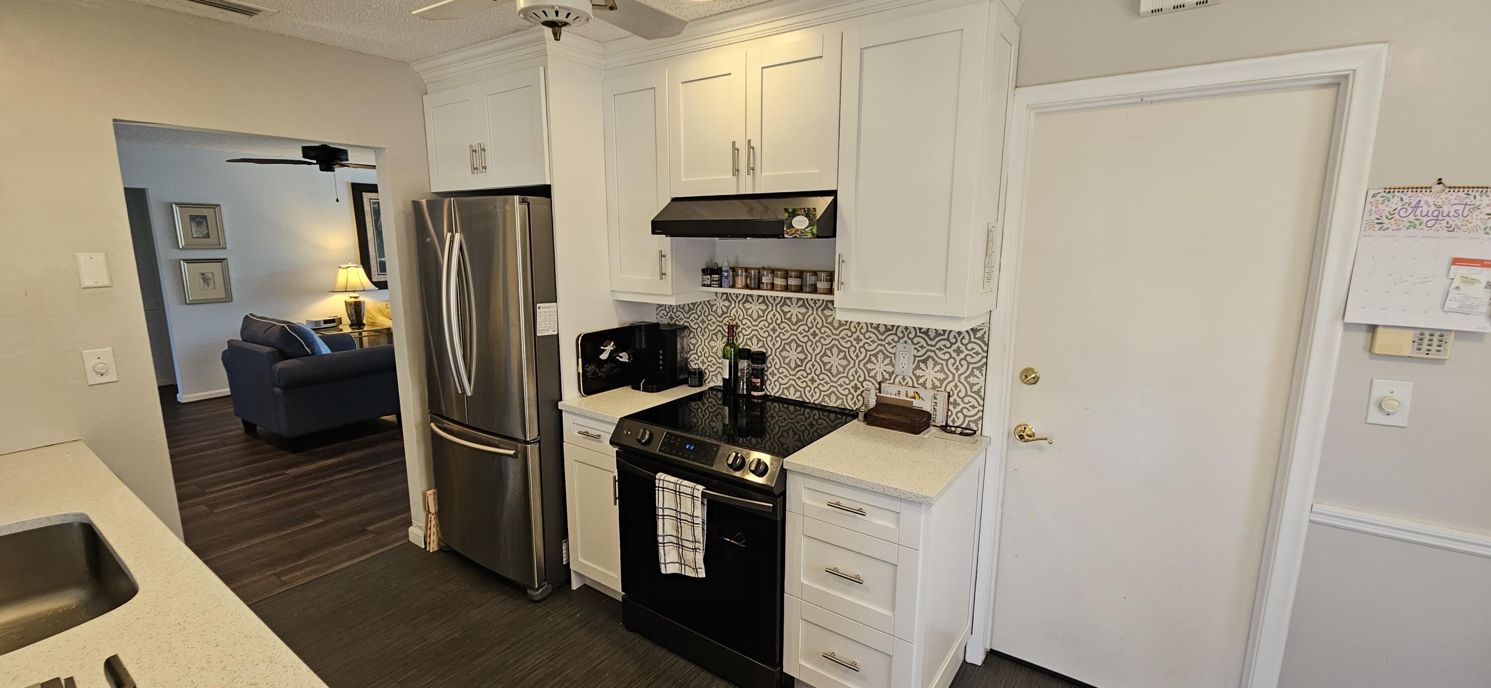 5213 Michael Drive West Palm Beach, FL 33417 - Photo 13 of 47 a kitchen with a refrigerator and a stove top oven