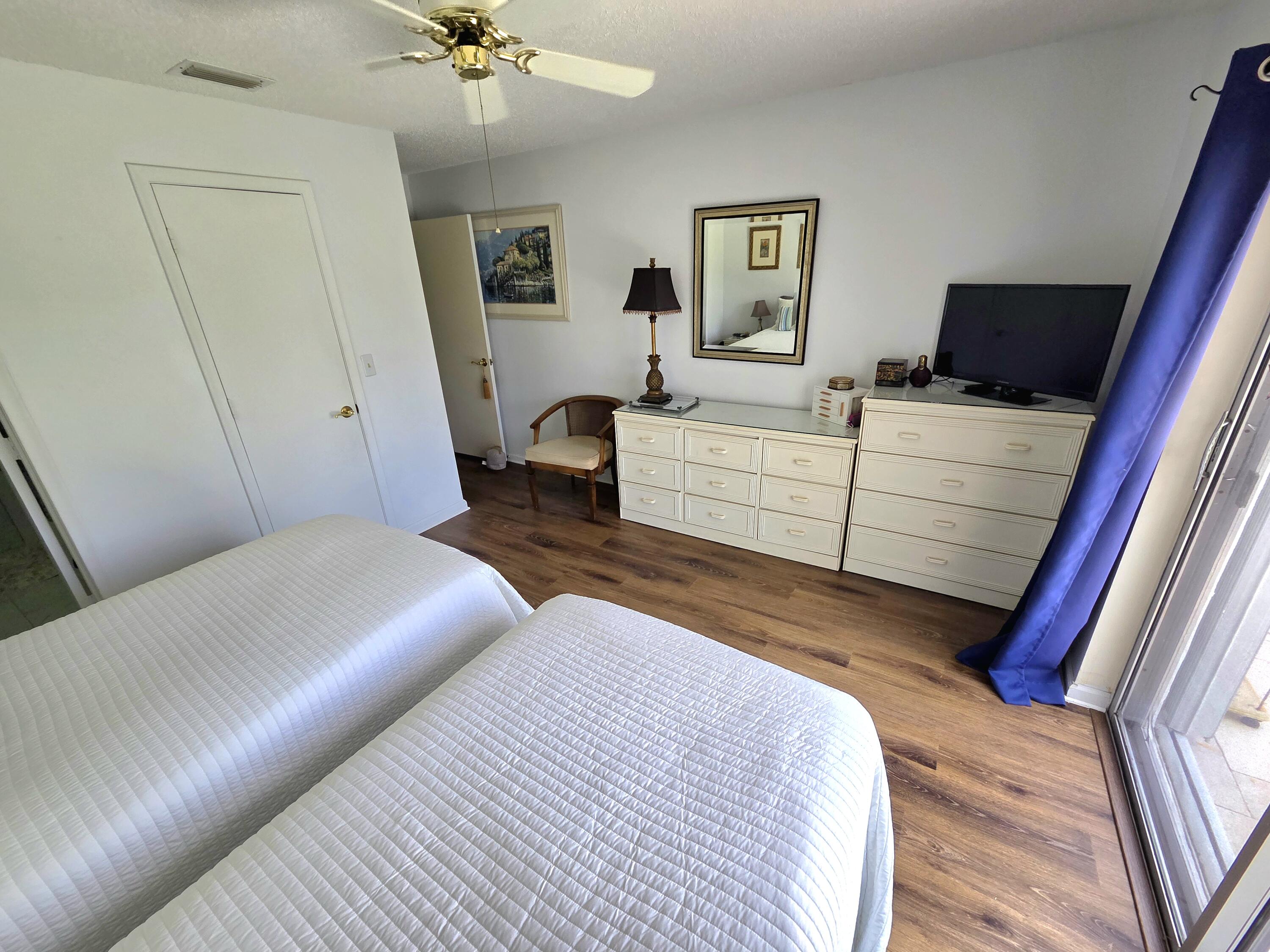 5213 Michael Drive West Palm Beach, FL 33417 - Photo 20 of 47 a bedroom with a bed and a chandelier