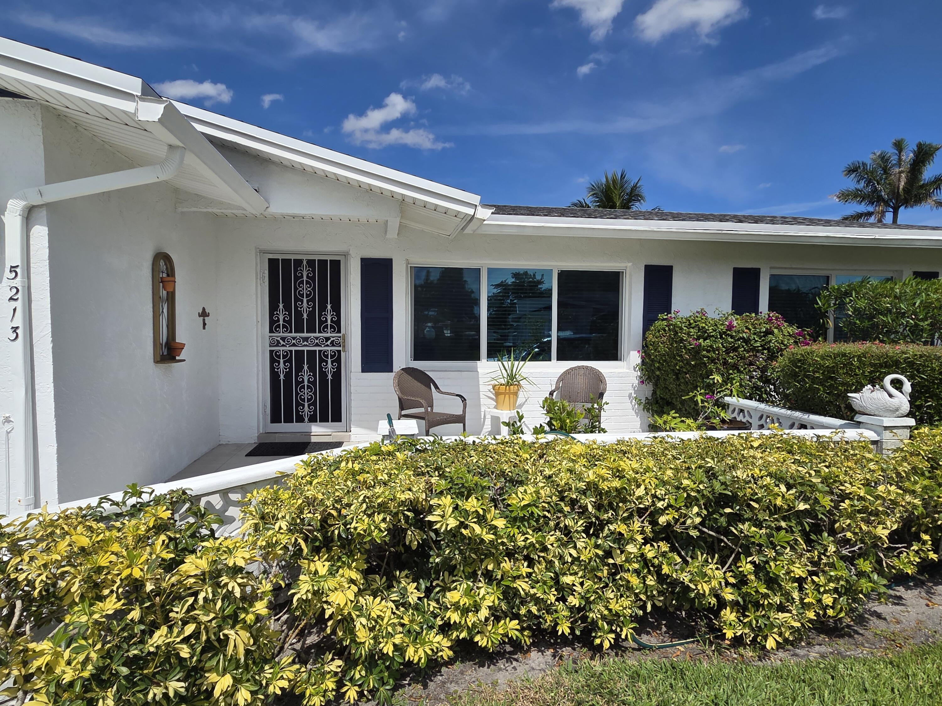 5213 Michael Drive West Palm Beach, FL 33417 - Photo 2 of 47 a front view of a house with a yard