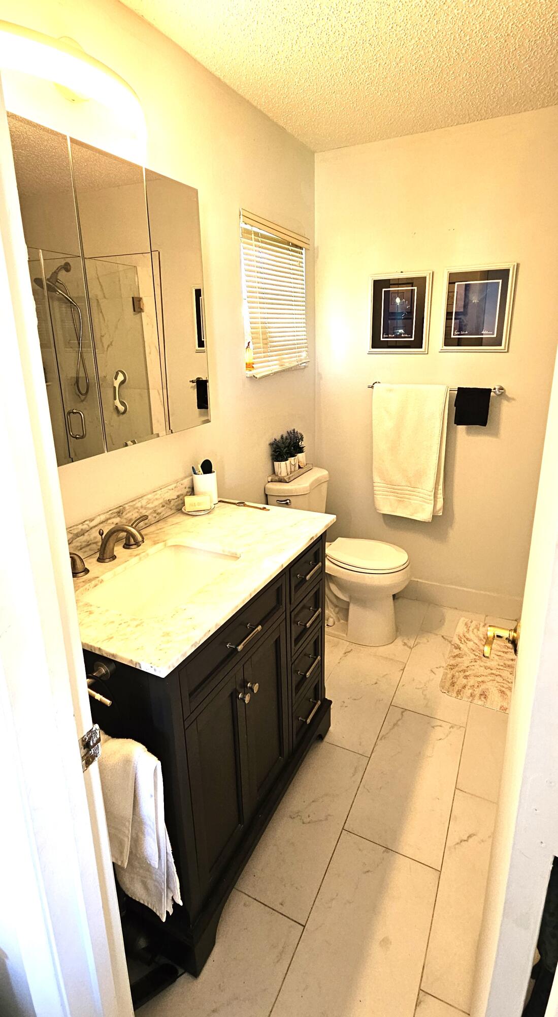 5213 Michael Drive West Palm Beach, FL 33417 - Photo 21 of 47 a bathroom with a sink a toilet and mirror